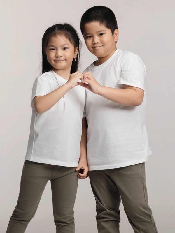 A boy and a girl making a heart shape with their hands