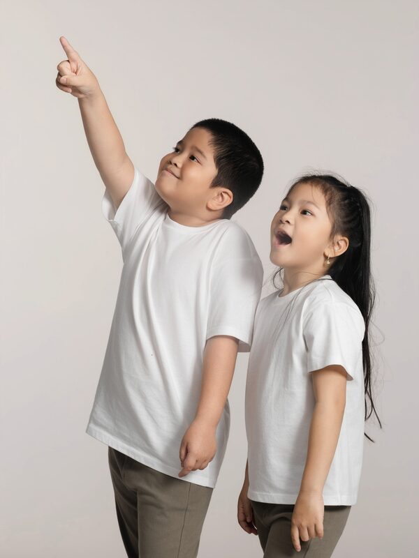 A boy and a girl looking up and pointing to the sky